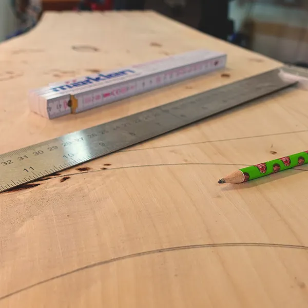 Holzbrett mit Lineal und Bleistift beim Anzeichnen in der Werkstatt